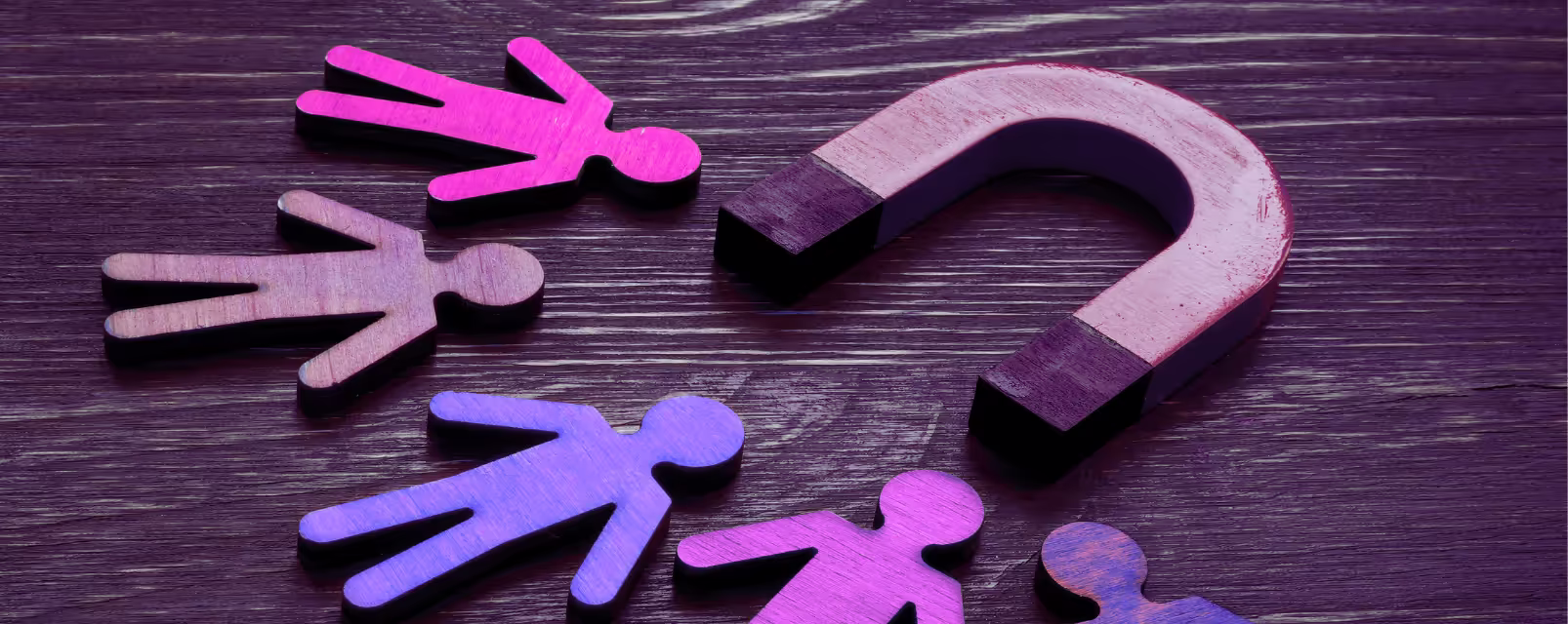 A magnet lying on a wooden surface with 5 cut out figures nearby. The image is describing customers attracted to businesses treating them well