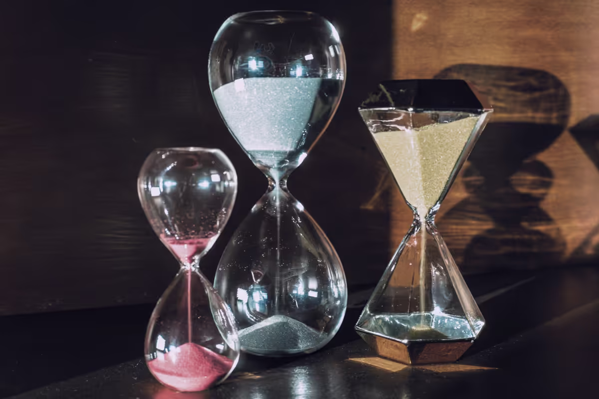 Three hourglasses with coloured sand, representing time limits for Summary Resolution Communications