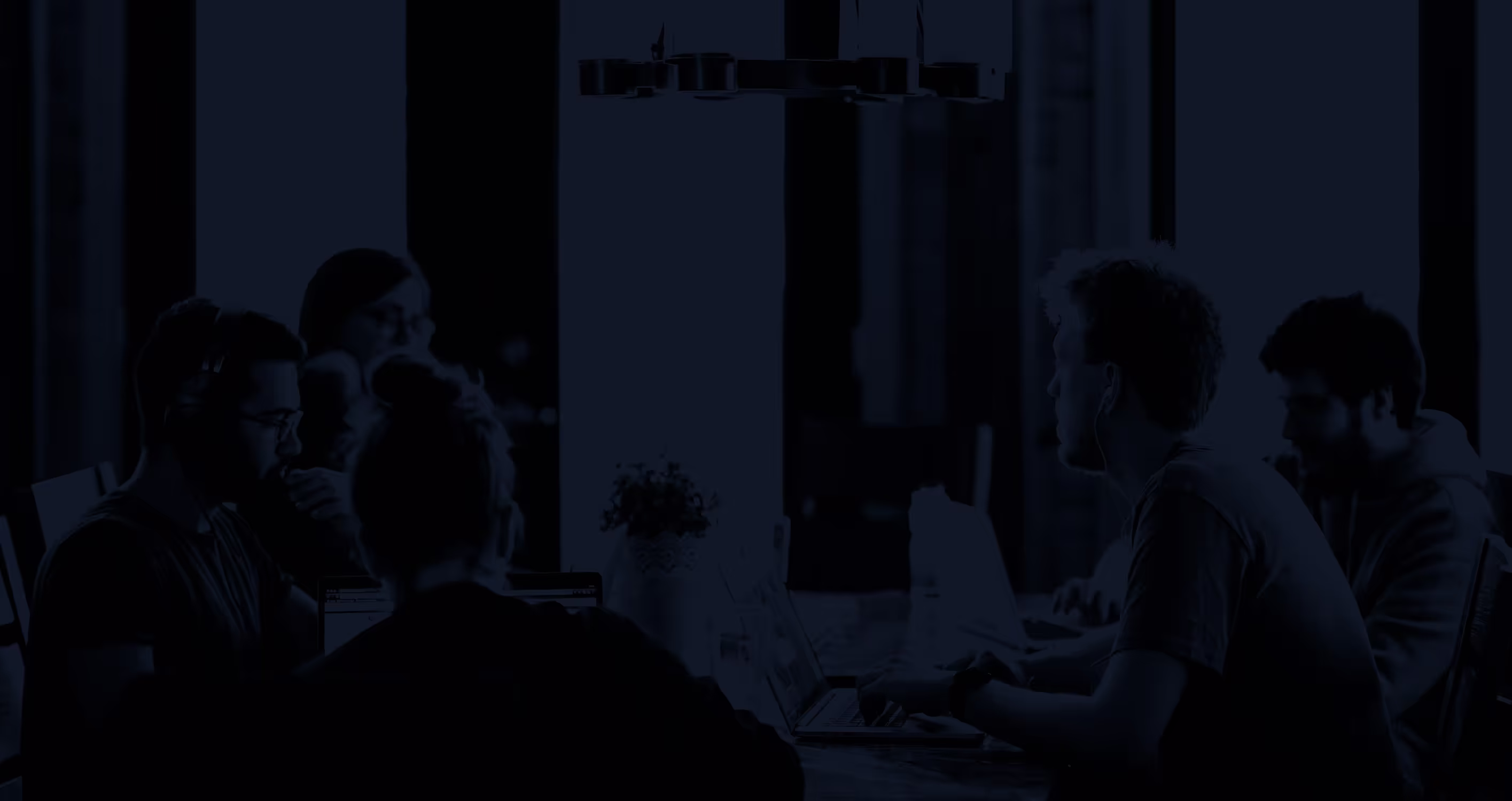 An open laptop showing a screen with skiing images. There are also two coffee cups on a table. The laptop user is scrolling images on a phone screen